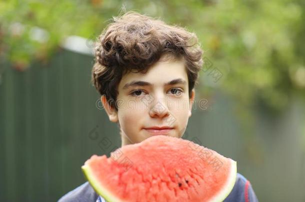 十几岁的青少年男孩和将切开水甜瓜关在上面照片