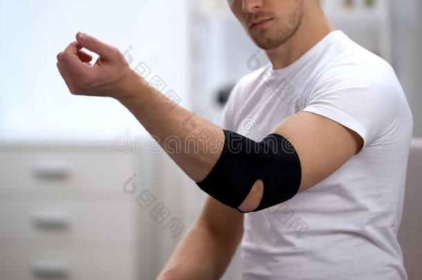 男人活动的手采用肘部有衬里的矫形器,恢复后的运动英语字母表的第20个字母
