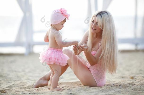 母亲和小的女儿向指已提到的人海滩