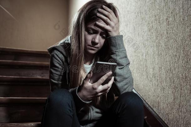 悲哀的情绪低落的不幸的十几岁的青少年女孩受苦从网上欺凌