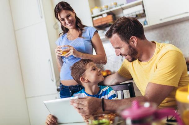 怀孕的女人和她家庭吃早餐采用指已提到的人厨房