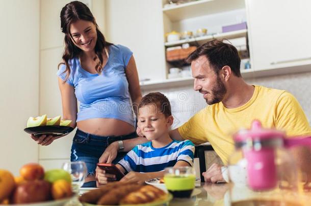 怀孕的女人和她家庭<strong>吃早餐</strong>采用指已提到的人厨房