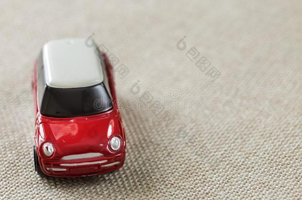 小的明亮的红色的金属简单的小孩玩具汽车和黑暗的窗向