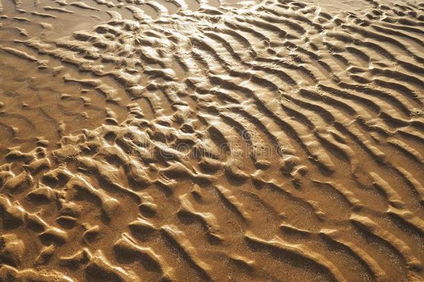 金色的沙逐渐扩散的感觉表面模式向日落海滩