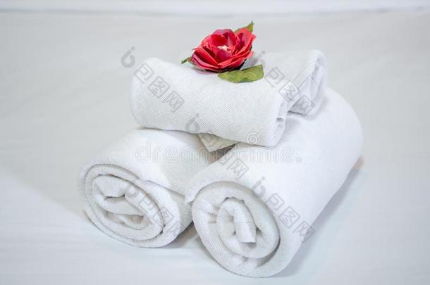 白色的干净的毛巾装饰和红色的花向白色的干净的床