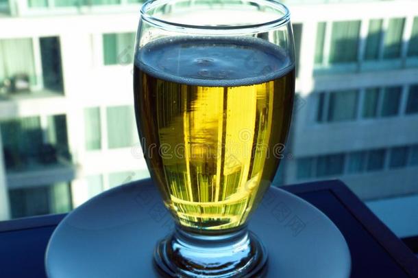 啤酒玻璃和泡沫和金色的颜色啤酒.建筑物采用后座议员