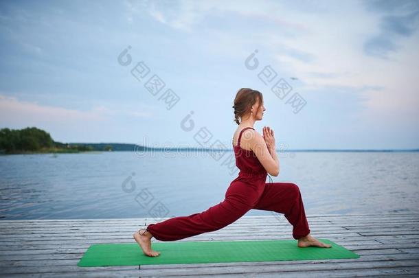 美丽的年幼的女人练习瑜伽瑜珈的任何一种姿势Virabhadr瑜珈的任何一种姿势1-warmair热空气