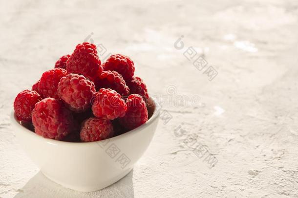 特写镜头关于碗关于新鲜的和成熟的红莓向指已提到的人白色的冲浪
