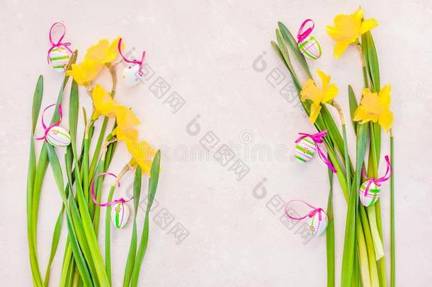 黄色的水仙花和复活节卵向粉红色的背景