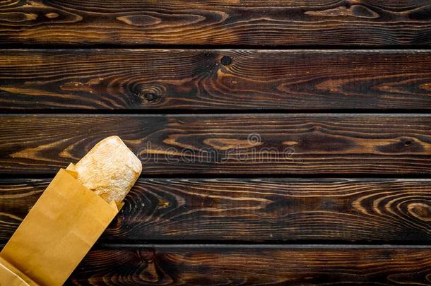 新鲜的法国长面包和纸袋为面包房向木制的背景顶
