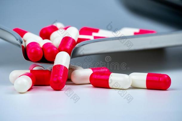 红色的-白色的抗生素胶囊药丸向不锈的钢药物盘子.