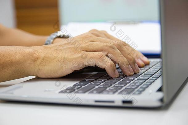 商业男人打字向便携式电脑键盘采用使工作办公室