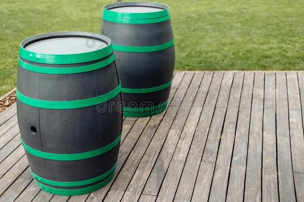 照片关于两个黑的和绿色的葡萄酒桶在户外.