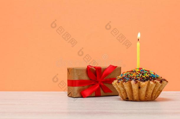 美味的生日英格兰松饼和燃烧的节日的蜡烛和一赠品盒