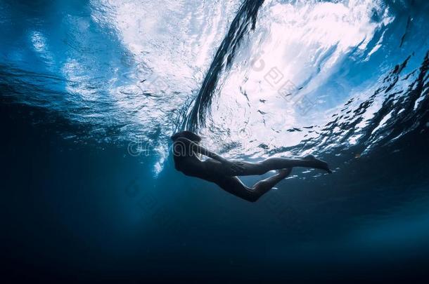 年幼的女人潜水在<strong>水中</strong>的和在下面桶<strong>波浪</strong>