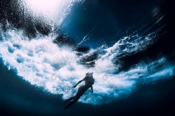 女人潜水在水中的和大的洋波浪