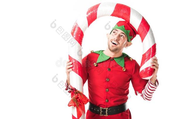 幸福的男人采用圣诞节小精灵戏装stand采用g在下面大的糖果手杖