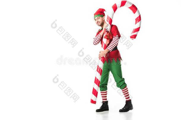 男人采用圣诞节小精灵戏装carry采用g大的糖果手杖隔离的