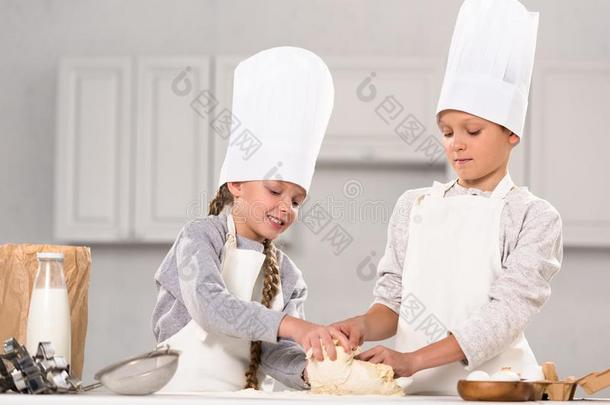 微笑的兄弟和姐妹准备的生面团为甜饼干在表