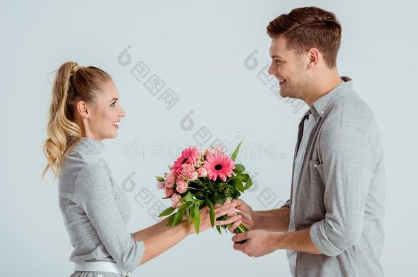 男人礼物粉红色的花花束向美丽的wo男人隔离的