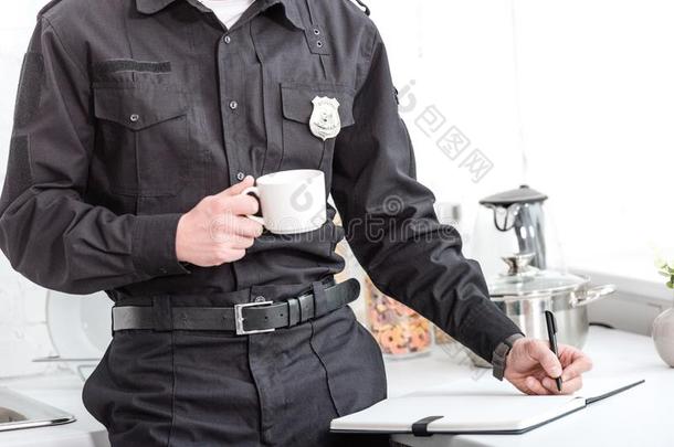 警察部门军官喝饮料咖啡豆和文字采用笔记簿