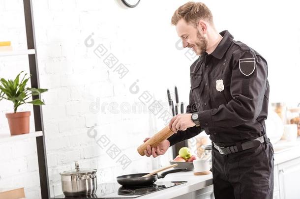 警察部门军官在上撒胡椒粉早餐在炉