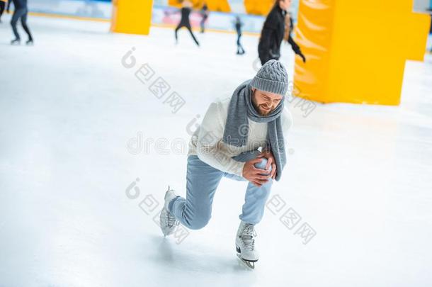 男人受伤的膝在期间滑冰