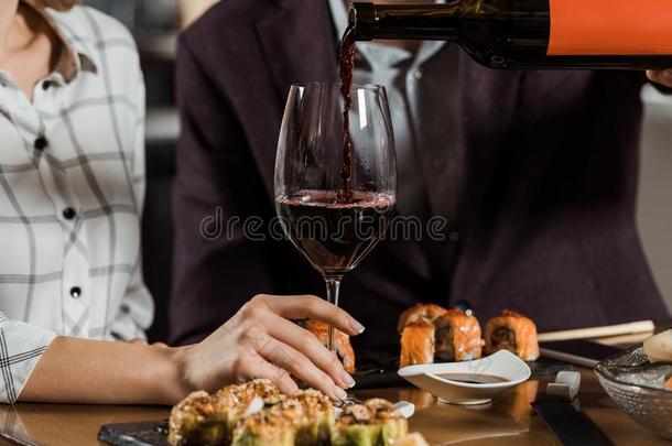裁切不正的看法关于男人传布红色的葡萄酒采用玻璃