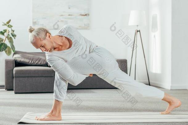 男人起立采用跳面角使摆姿势向瑜伽席子