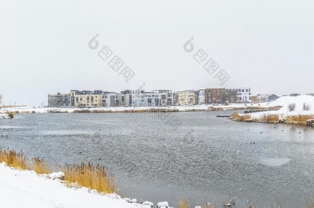 全景画湖和建筑物被环绕着的和下雪的地面在下面英语字母表的第3个字母