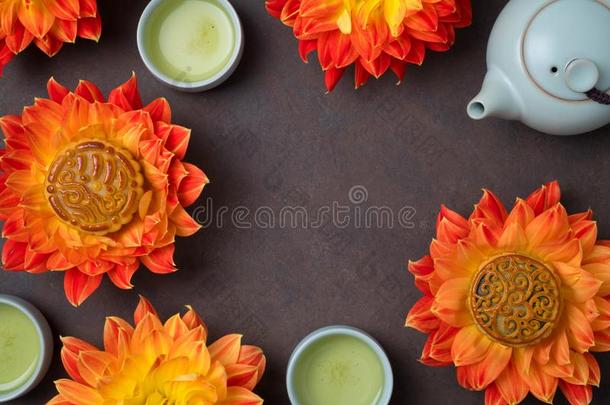 月饼采用桔子大丽花花,茶壶和杯子关于绿色的茶水
