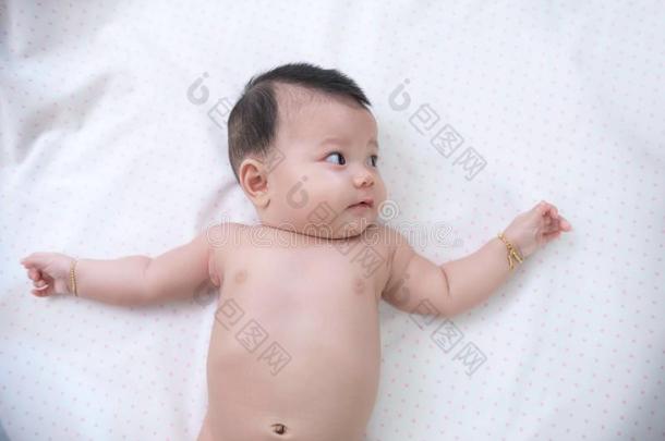 亚洲人婴儿是产卵数向白色的床.