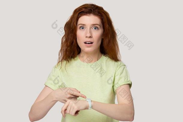 强调红发的人女人点手指向腕注视工作室头