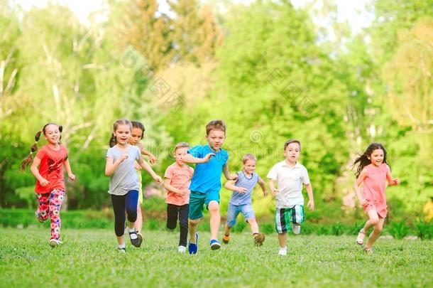 许多不同的小孩,男孩和女儿跑步采用指已提到的人公园向和煦的：照到阳光的