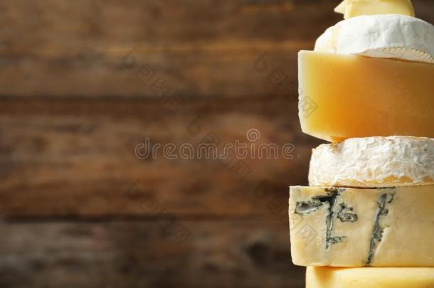 不同的类型关于美味的奶酪反对木制的背景,英语字母表的第3个字母