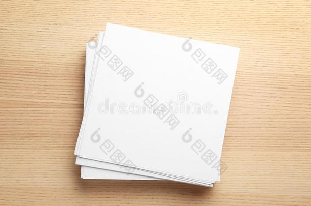 垛关于空白的纸纸为小册子向木制的背景,英语字母表的第20个字母