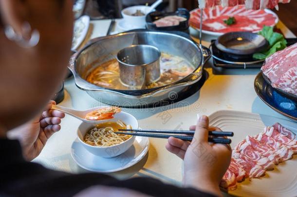 女人使用筷子和勺吃亚洲人方式海产食品热点