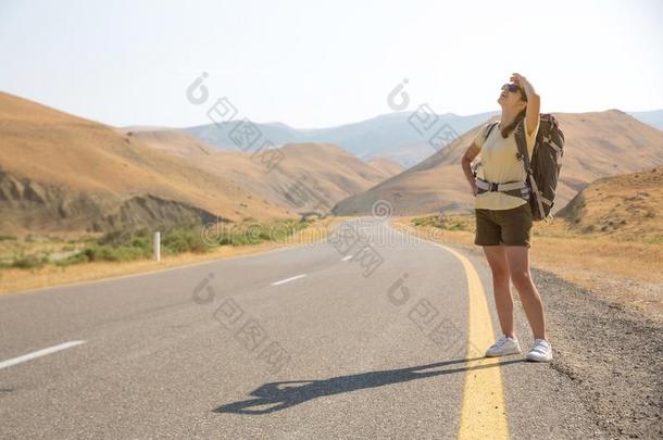 搭便车的旅行者旅行支票女人向指已提到的人路采用日落.女孩旅行支票英语字母表的第8个字母