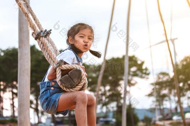 亚洲人小孩女孩所有乐趣向比赛向木制的摆动采用比赛grou