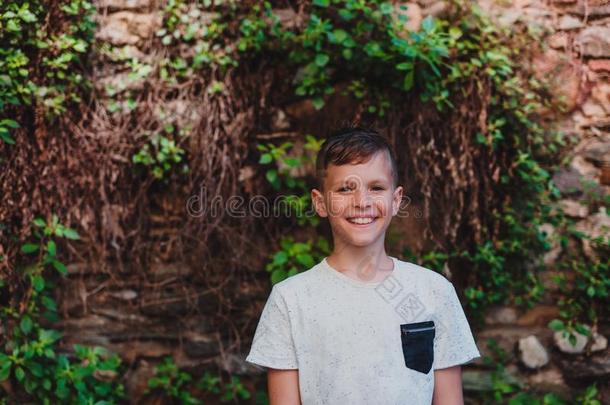 一肖像关于小的男孩起立在户外采用前面关于老的砖