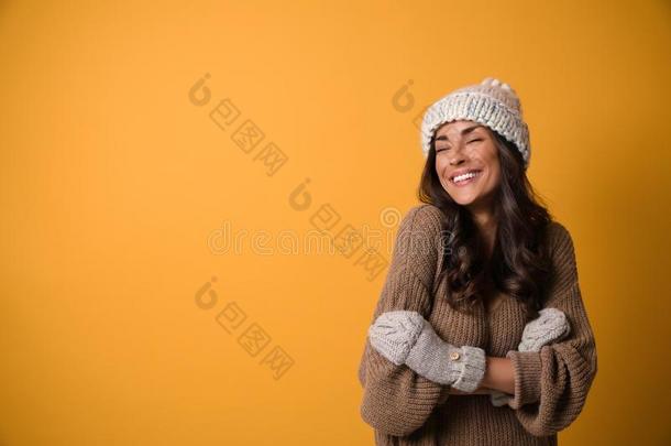 年幼的女人采用暖和的毛衣,帽子和连指手套向背景,休闲健身中心