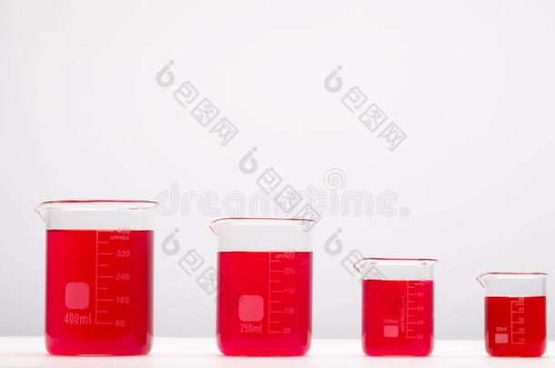 实验室设备,高脚杯满的在旁边红色的液体向白色的tablet药片