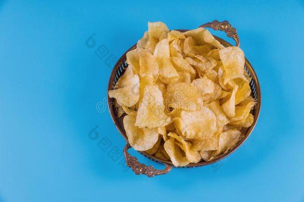易碎的马铃薯炸马铃薯条采用银碗向蓝色背景