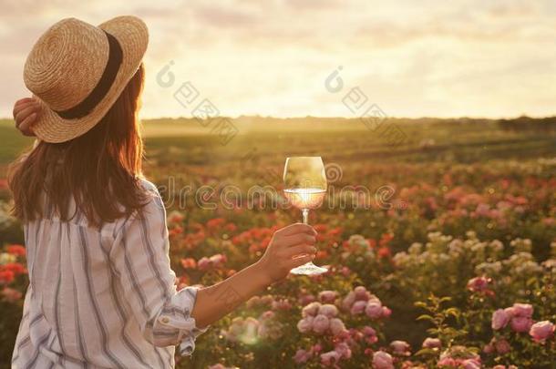 女人和玻璃关于<strong>葡萄</strong>酒采用<strong>玫瑰</strong>花园向和煦的：照到<strong>阳光</strong>的一天