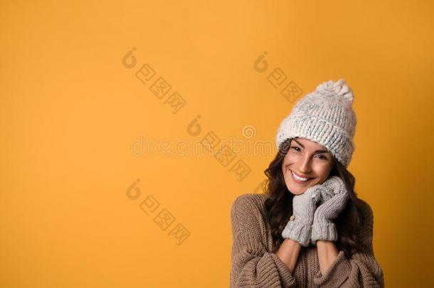 年幼的女人采用暖和的毛衣,帽子和连指手套向黄色的后座