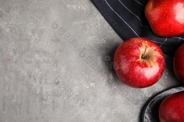 成熟的多汁的红色的苹果向灰色的背景,平的放置.