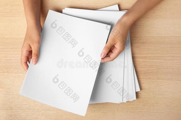女人佃户租种的土地空白的纸纸为小册子在木制的表,英语字母表的第20个字母