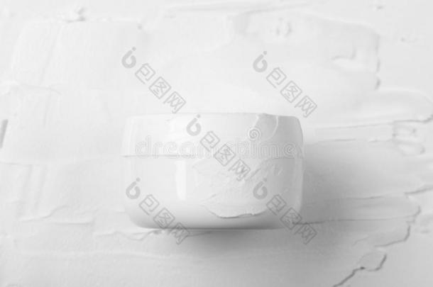 关闭着的白色的罐子污染的和白色的面容乳霜向一b一ckground关于