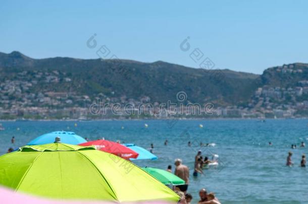 许多旅行者和太阳伞向指已提到的人海滩在夏时间