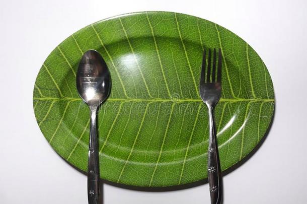 绿色的盘子叶子主题隔离的白色的背景和勺和